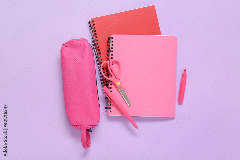 Notebook with pencil case and different stationery on lilac background