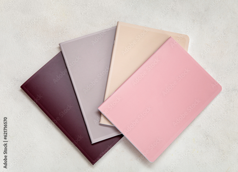 Different colorful notebooks on white background