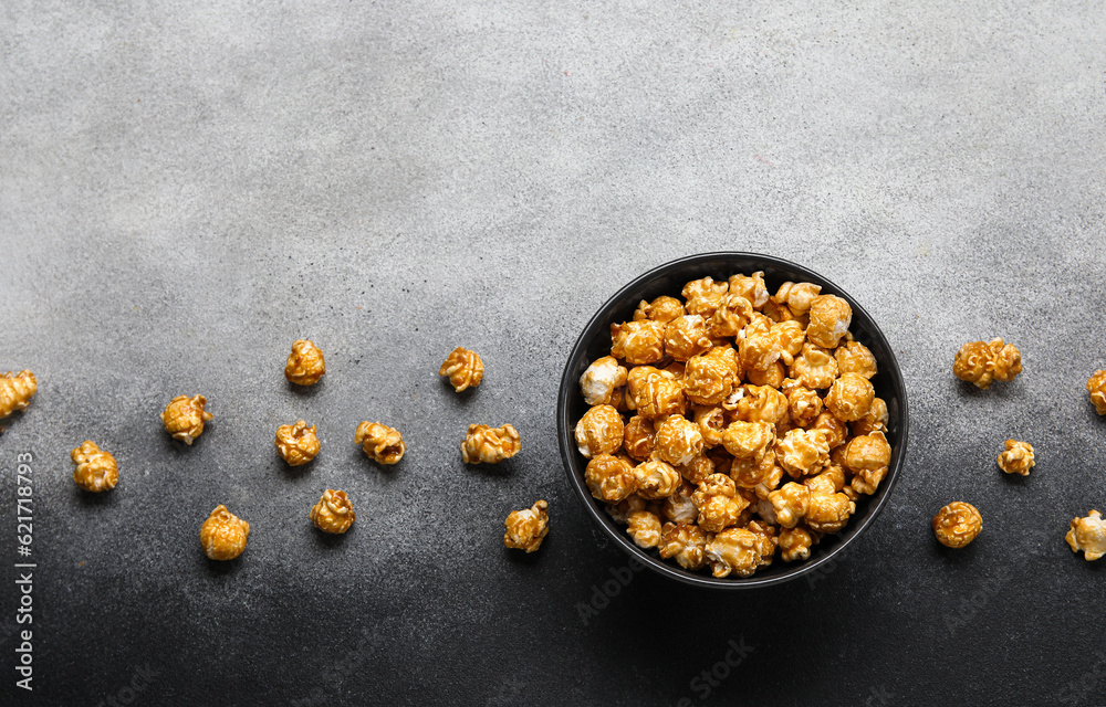 Bowl with tasty popcorn on grey background