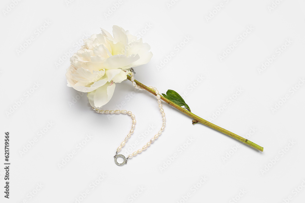 Beautiful peony flower with stylish female necklace on white background