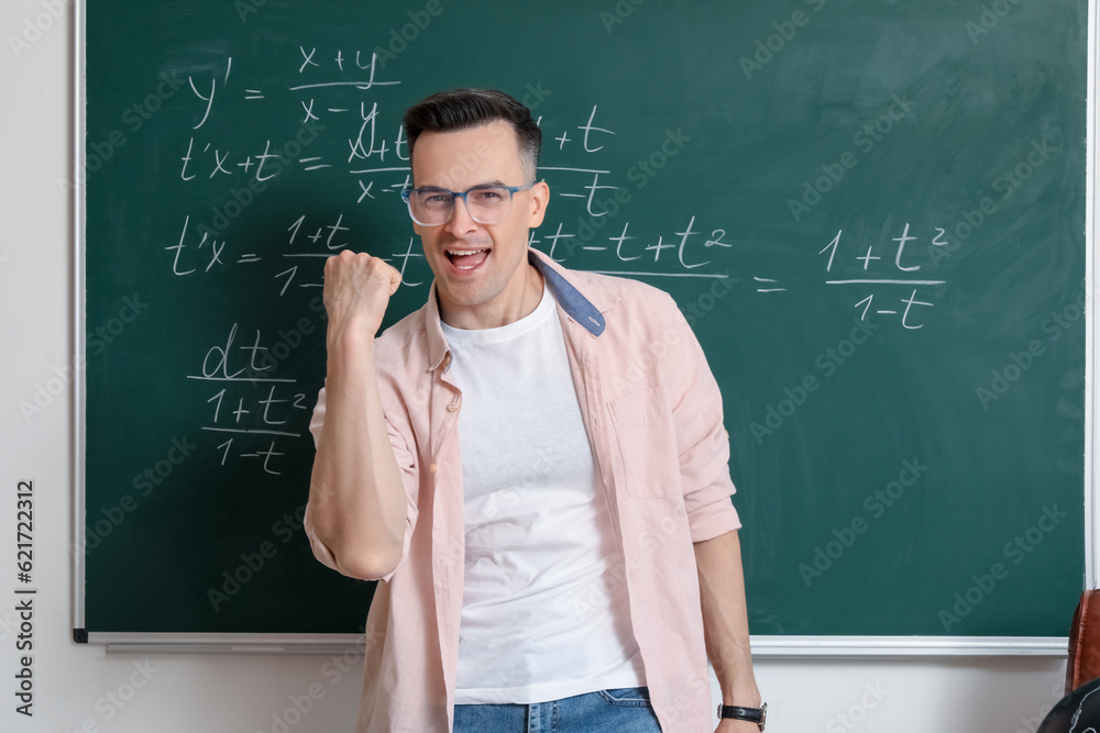 Happy Math teacher near chalkboard in classroom