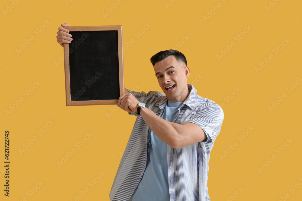 Male teacher with chalkboard on yellow background