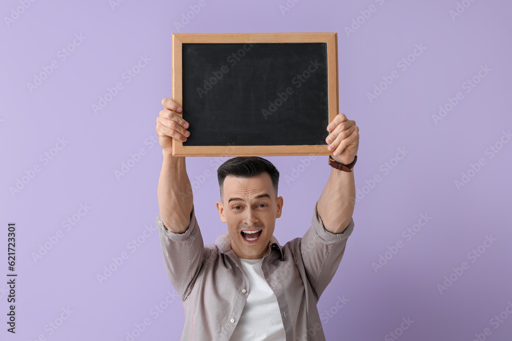 Male teacher with chalkboard on lilac background