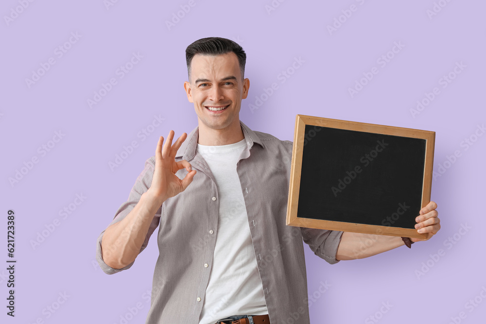 Male teacher with chalkboard showing OK on lilac background