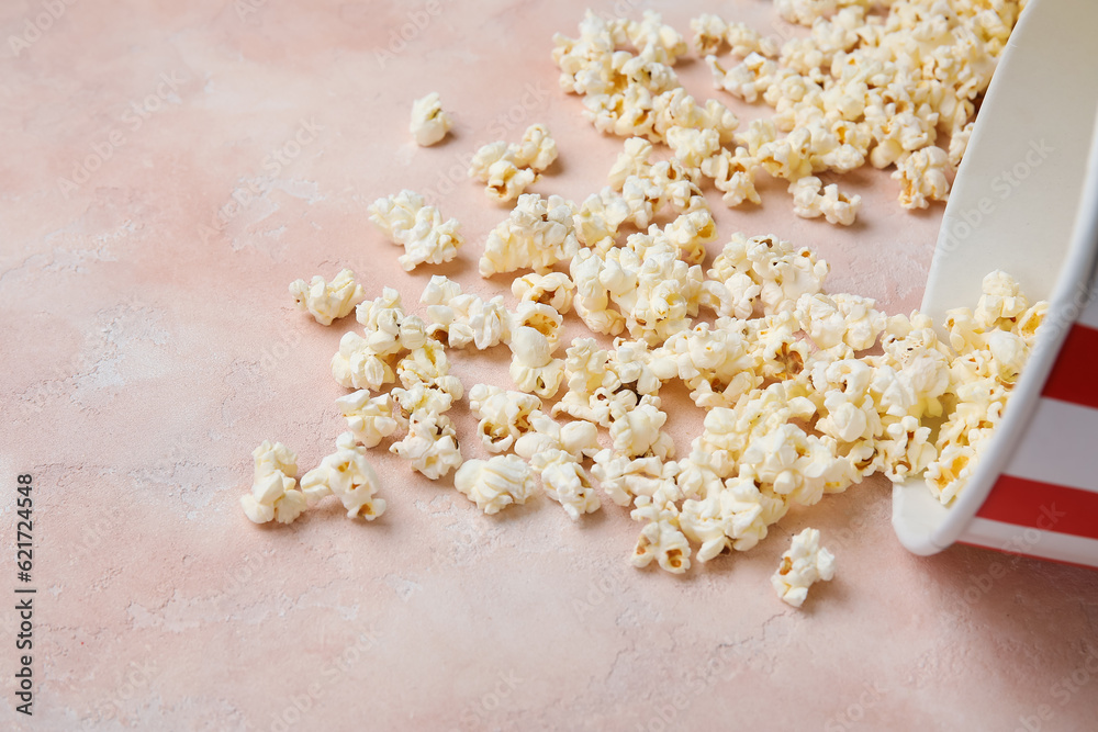 Bucket with tasty popcorn on pink background