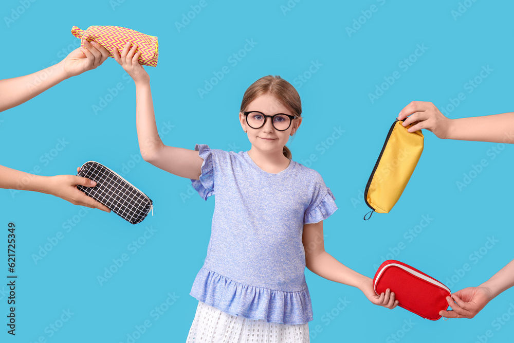 Little girl and hands with pencil cases on blue background