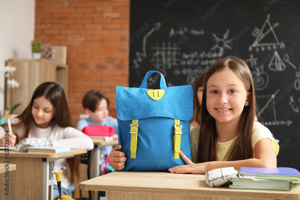 Little girl with backpack in classroom