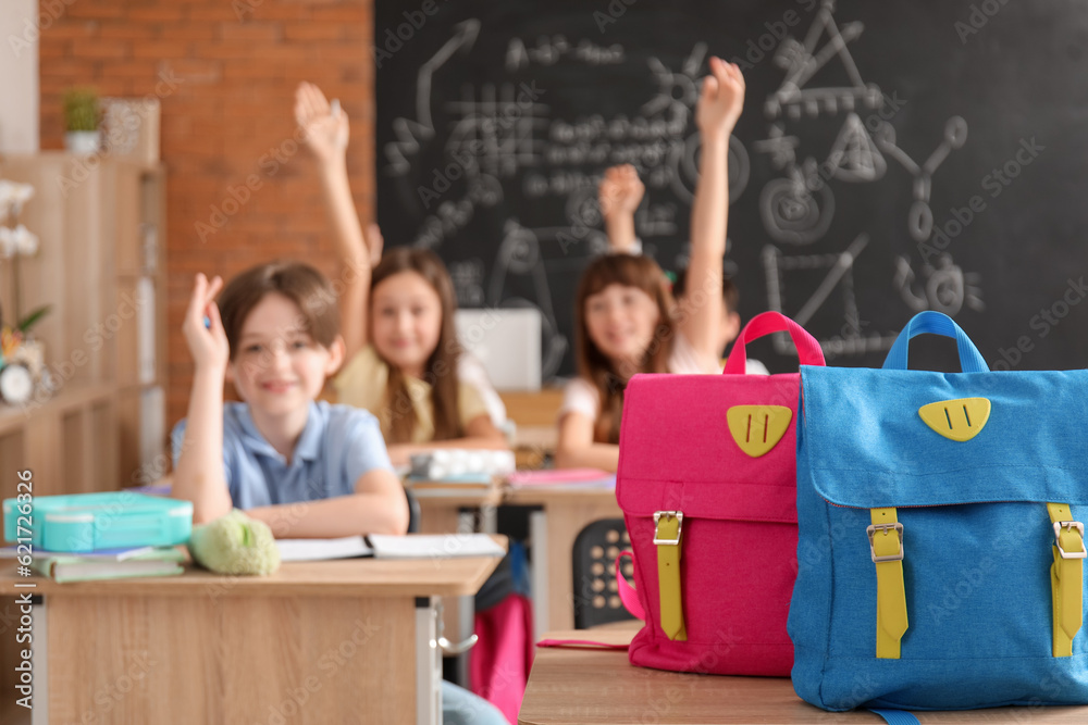 Backpacks on desk in classroom, closeup