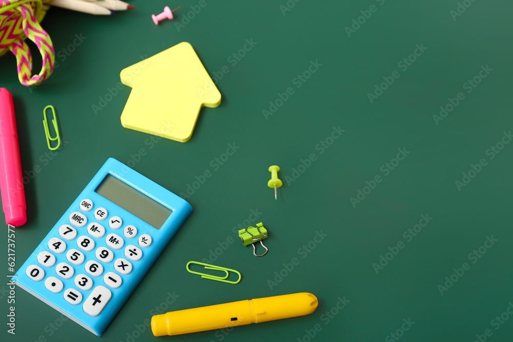 Calculator with different stationery on green chalkboard