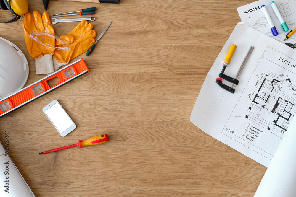 Frame made of builders supplies with mobile phone on wooden table, top view