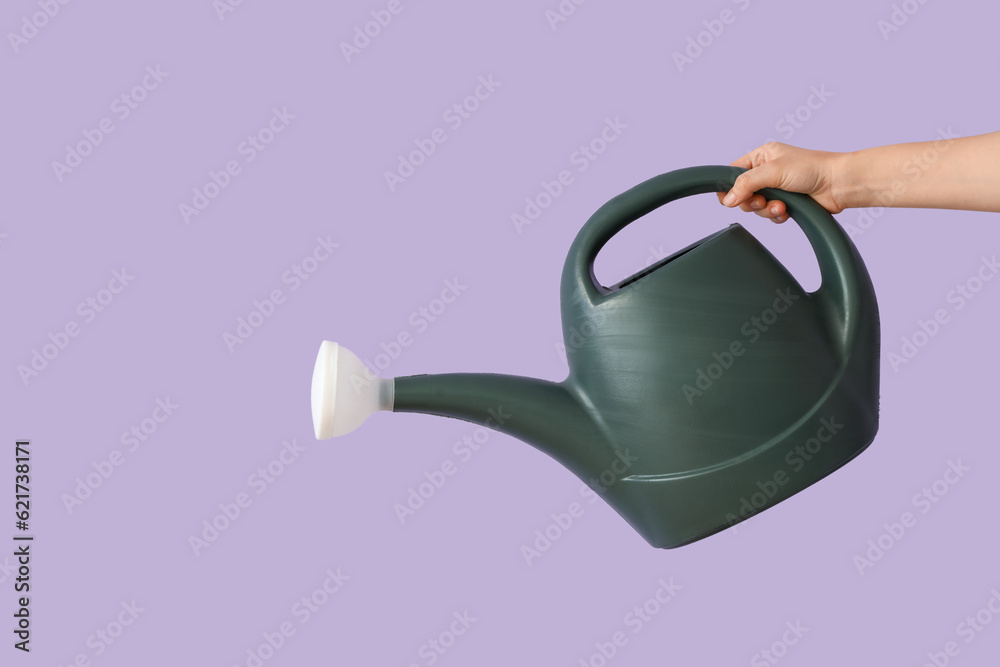 Gardener with watering can on lilac background