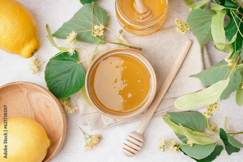 Bowl and jar with linden honey on white background