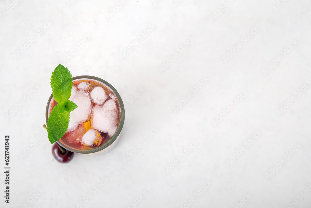 Glass of tasty cherry lemonade with mint on white background