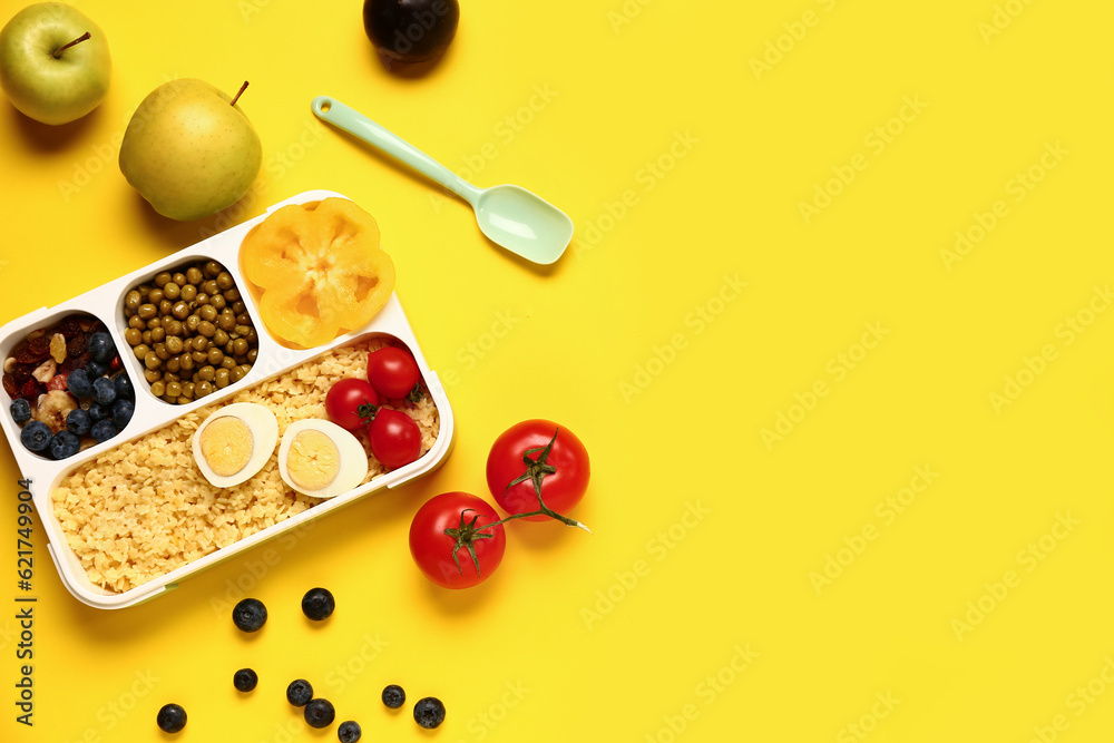 Fruits, vegetables and lunchbox with tasty food on yellow background