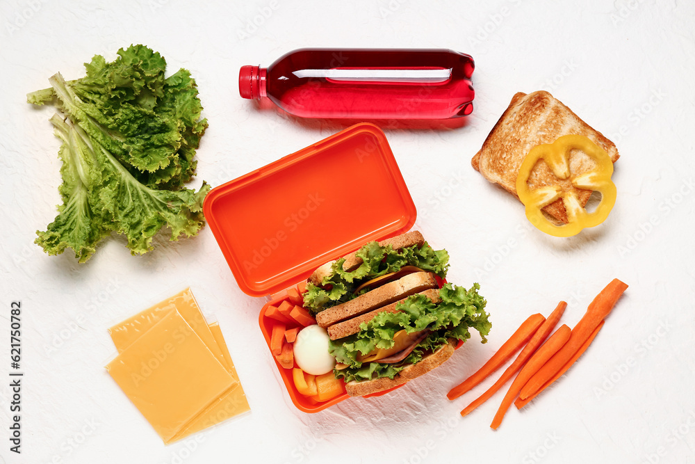 Bottle of juice, vegetables and lunchbox with tasty food on white background