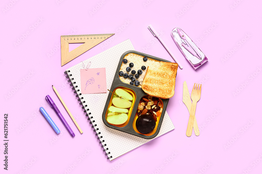 Different stationery and lunchbox with tasty food on lilac background