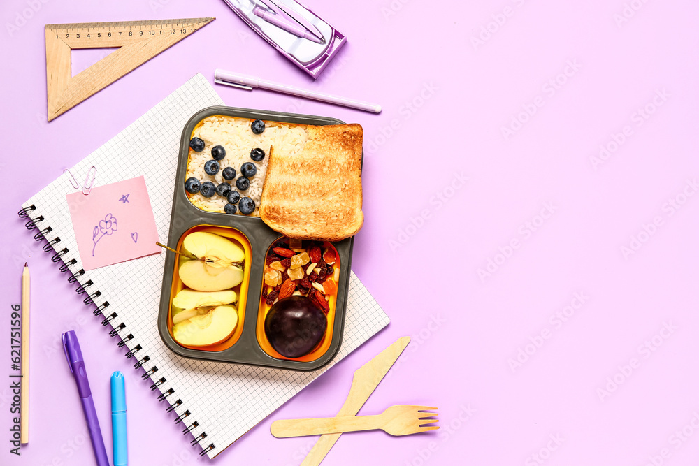 Different stationery and lunchbox with tasty food on lilac background