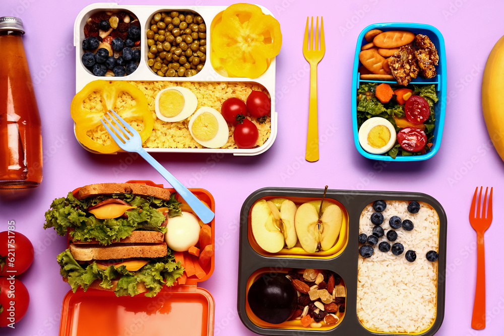 Lunchboxes with different tasty food on lilac background