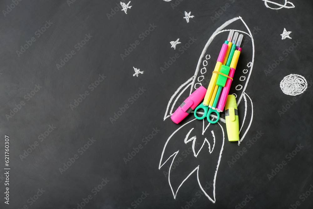 Drawn rocket with stationery on black background