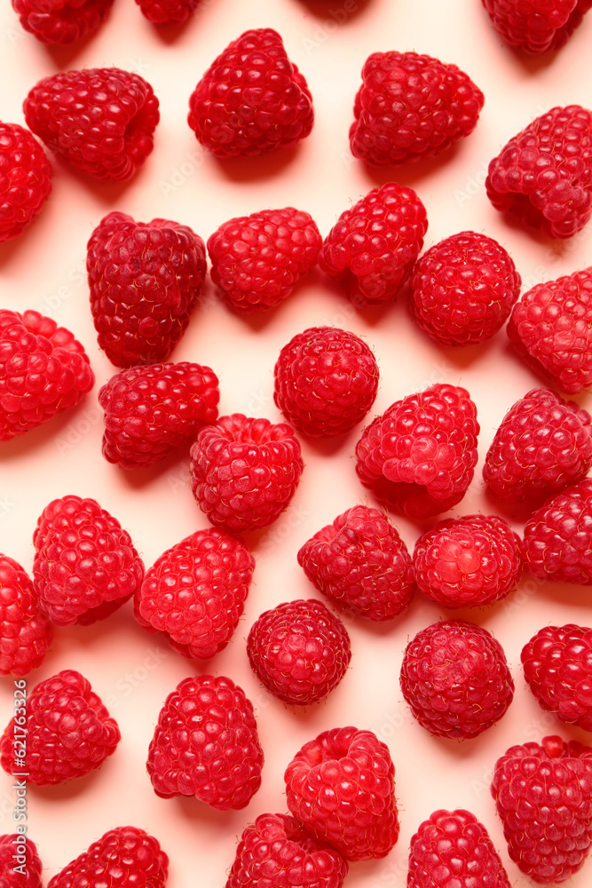 Many fresh raspberries on pink background