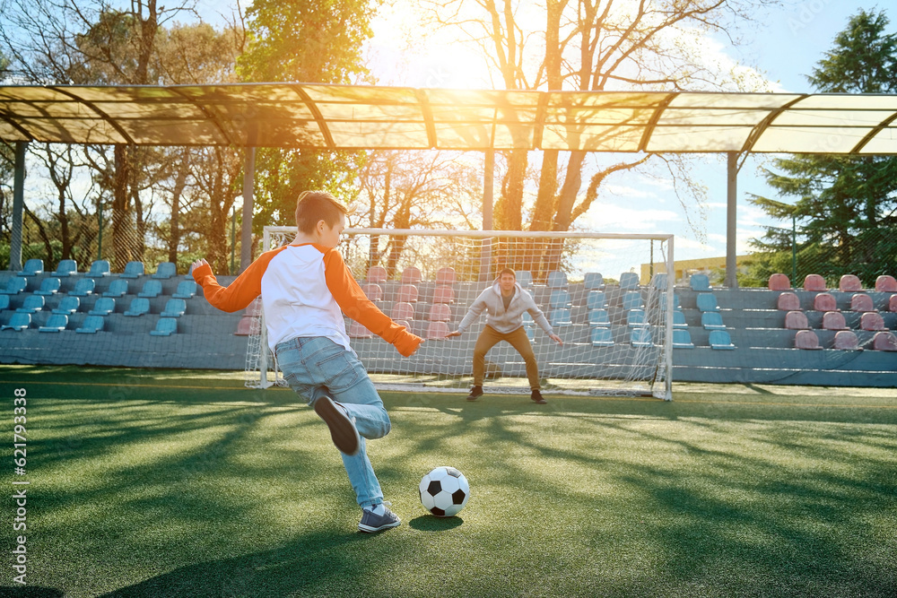 Father and Son play football on stadium outdoors, Happy family bonding, fun, players in soccer in dy