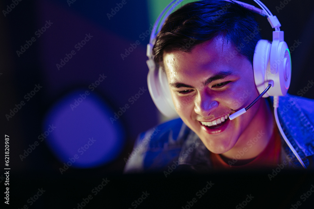 Player smiling at his computer screen during an online video gaming session