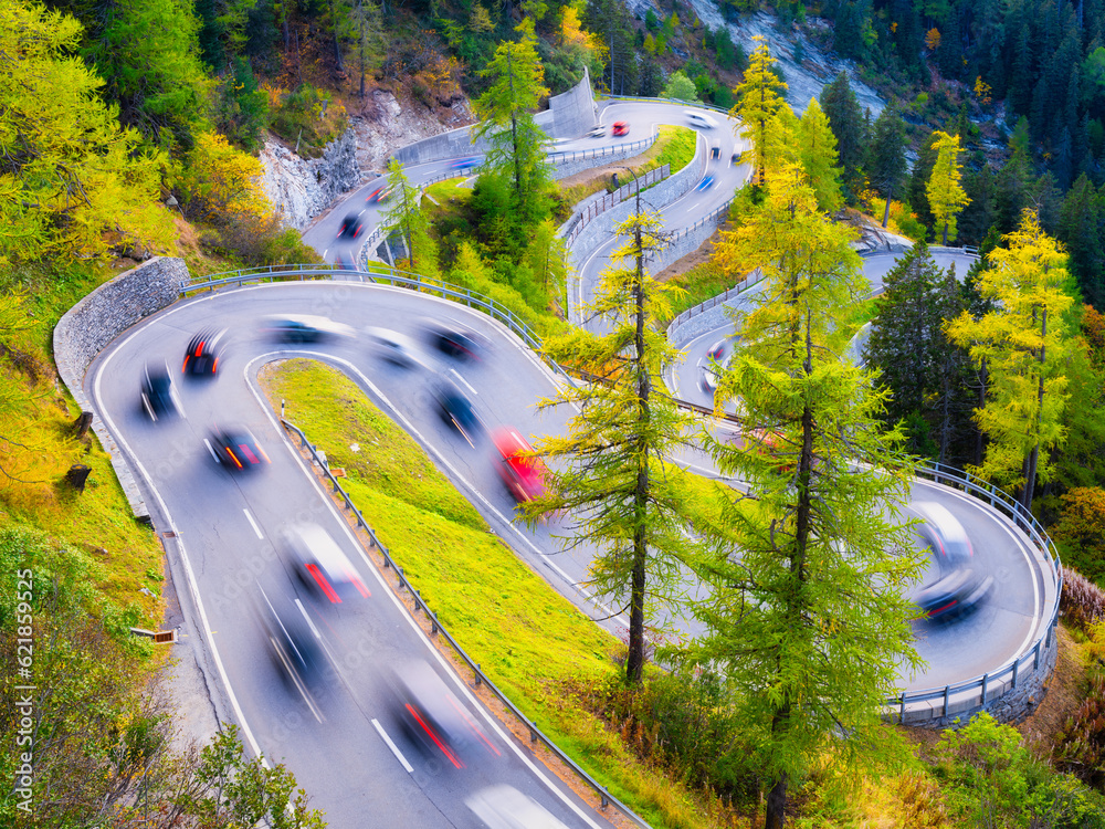 The mountain pass of Maloja, Switzerland. A road with many curves among the forest. Transportation. 