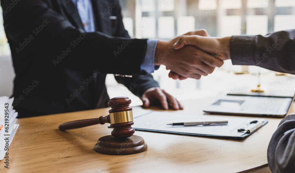 Businessman shaking hands to seal a deal with his partner lawyers or attorneys discussing a contract