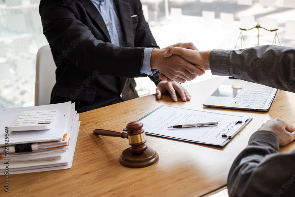 Businessman shaking hands to seal a deal with his partner lawyers or attorneys discussing a contract