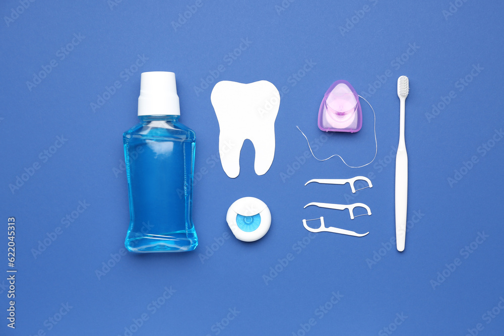 Set for oral hygiene and tooth model on blue background