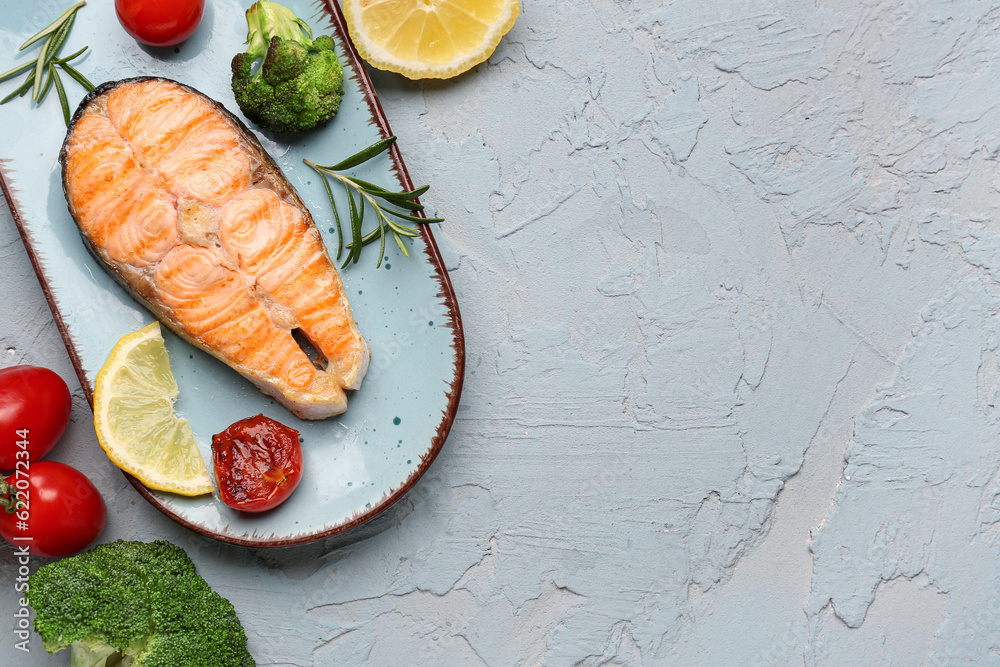 Plate with tasty grilled salmon steak on grey background