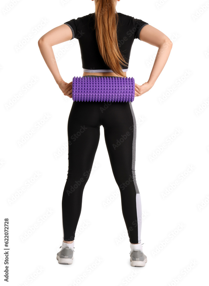 Young woman in sportswear and with foam roller on white background, back view