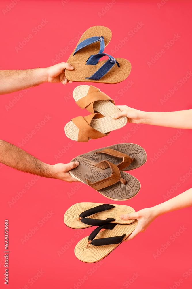 Hands with flip-flops on red background