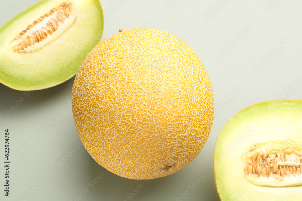 Sweet melon with pieces on grey background