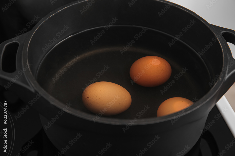 Chicken eggs boiling in cooking pot, closeup