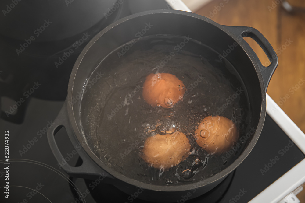 Chicken eggs boiling in cooking pot, closeup