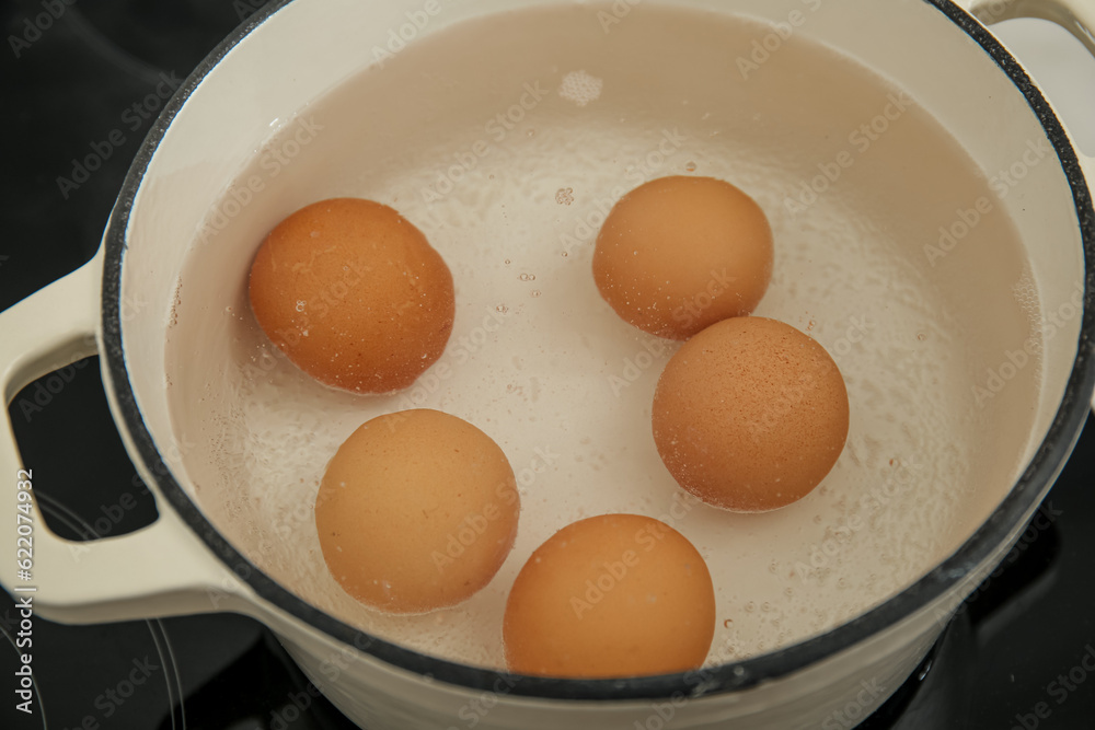 Chicken eggs boiling in cooking pot, closeup