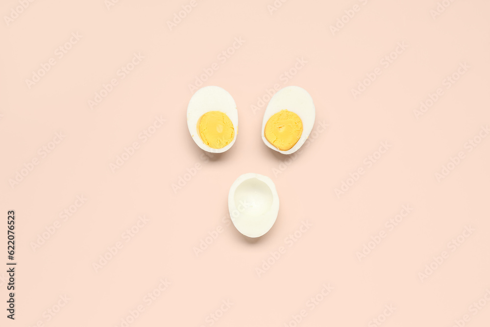 Halves of tasty boiled eggs on pink background