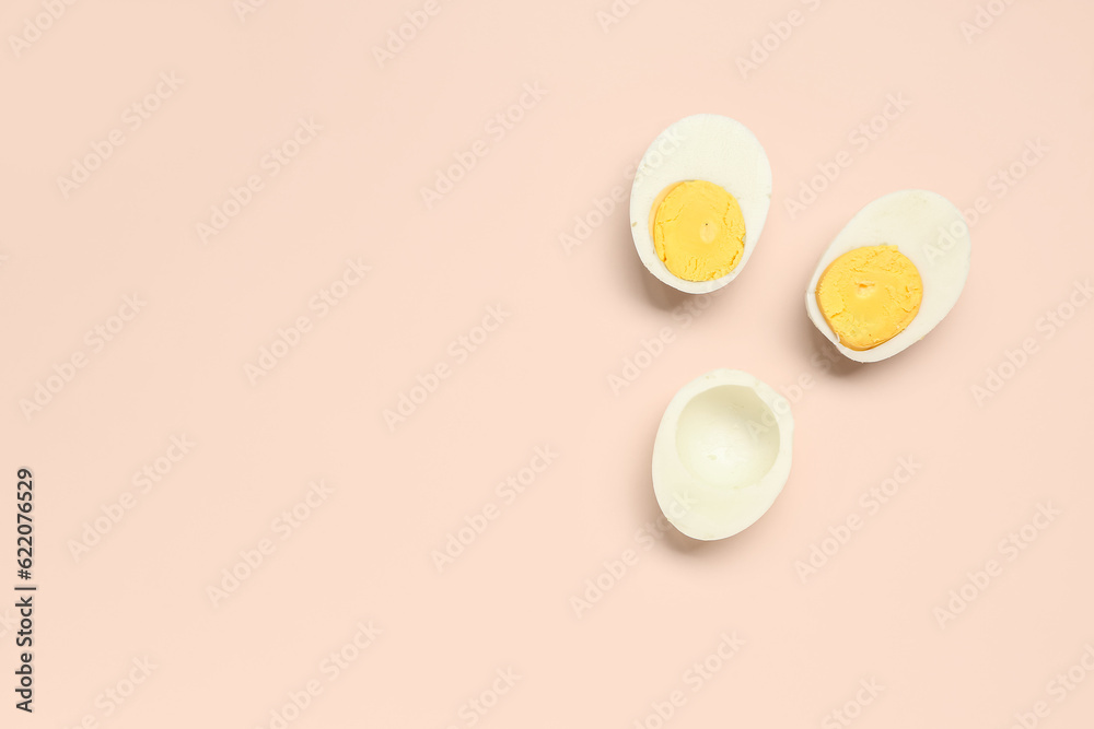 Halves of tasty boiled eggs on pink background