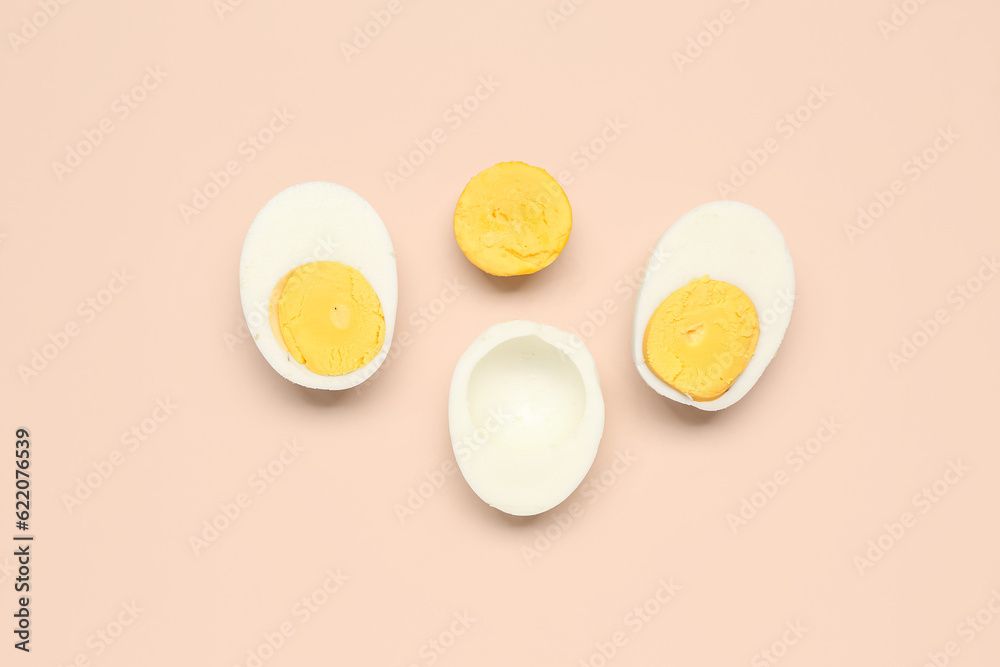 Halves of tasty boiled eggs on pink background