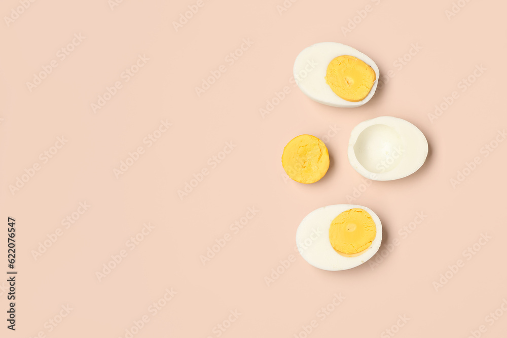 Halves of tasty boiled eggs on pink background