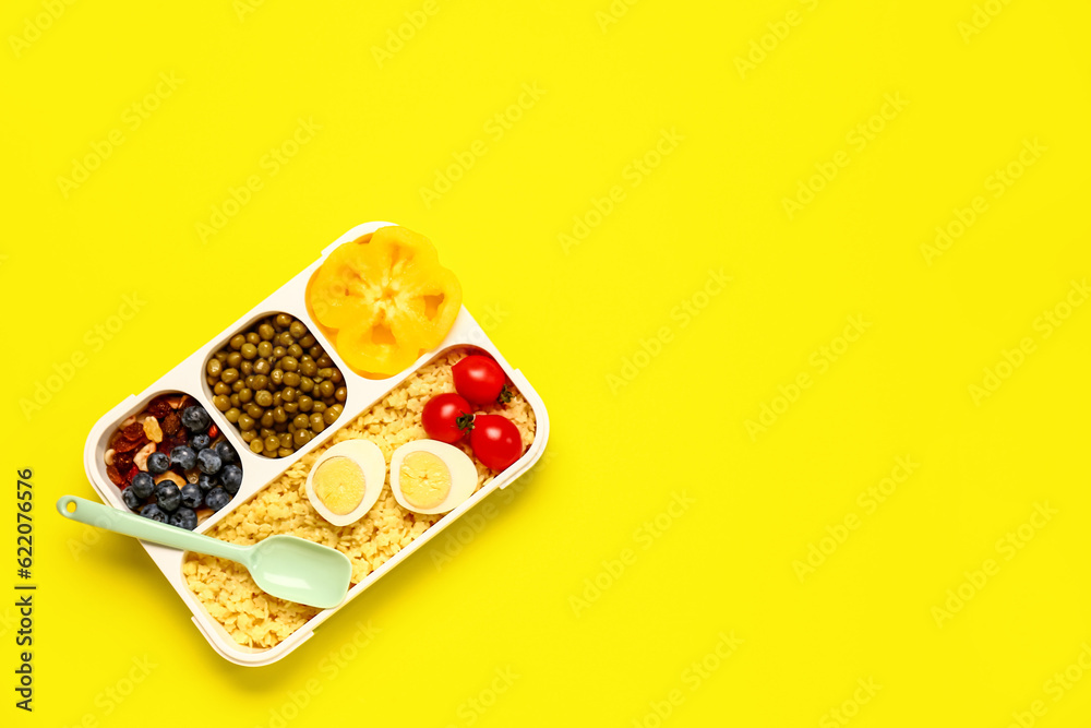 Lunchbox with tasty food on yellow background