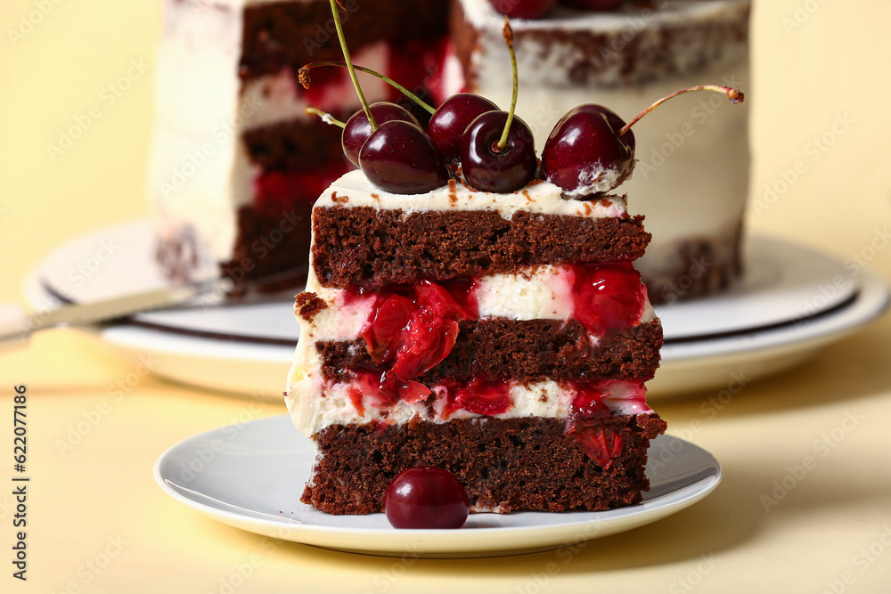 Plate with piece of tasty cherry cake on yellow background