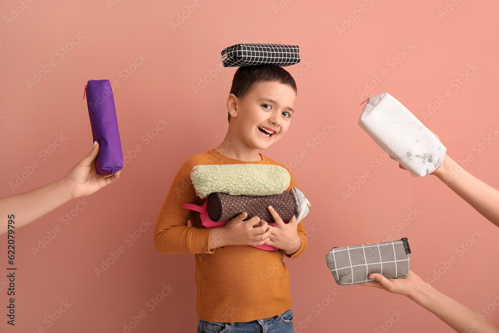 Cute little boy and female hands with pencil cases on color background