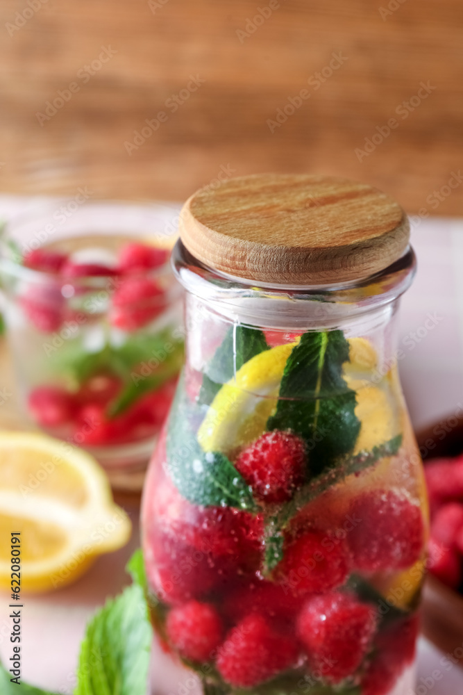 Bottle of fresh raspberry lemonade with mint on wooden background, closeup