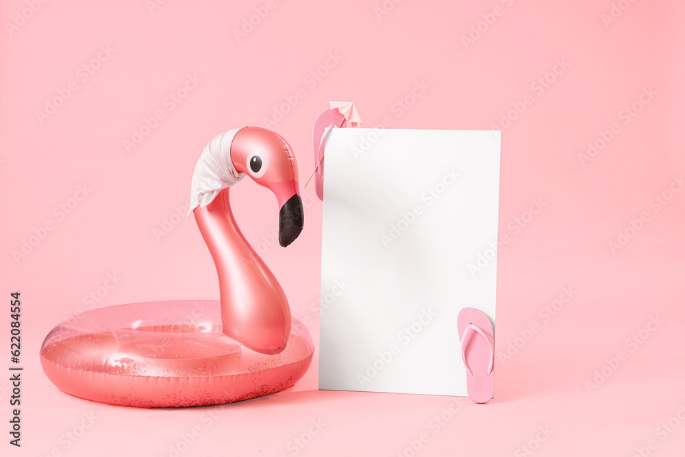 Blank poster with inflatable ring in shape of flamingo on pink background. Travel concept