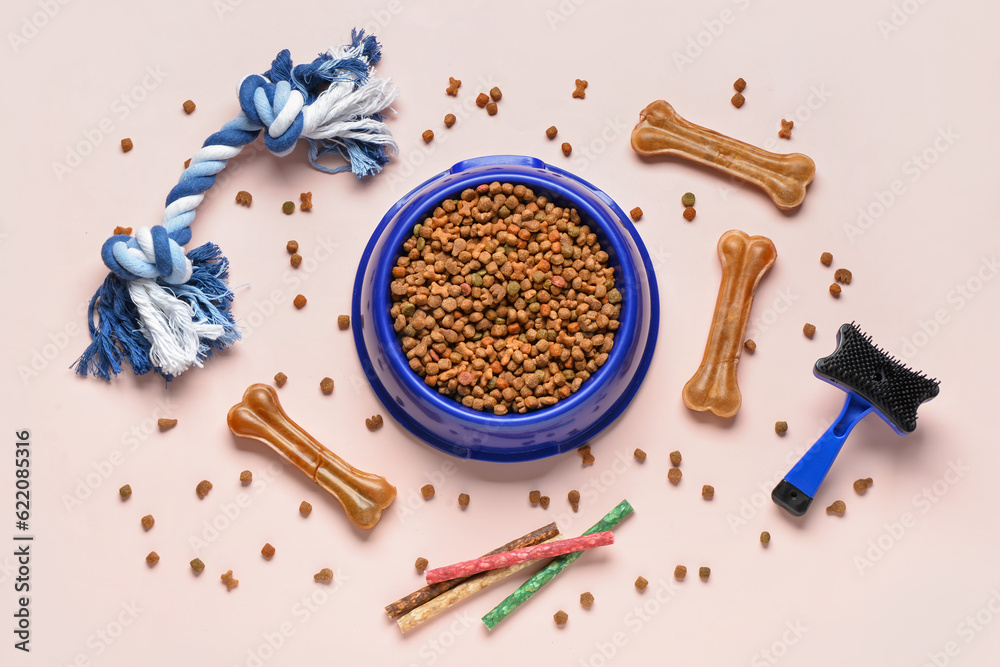 Composition with bowl of dog food and accessories on light background