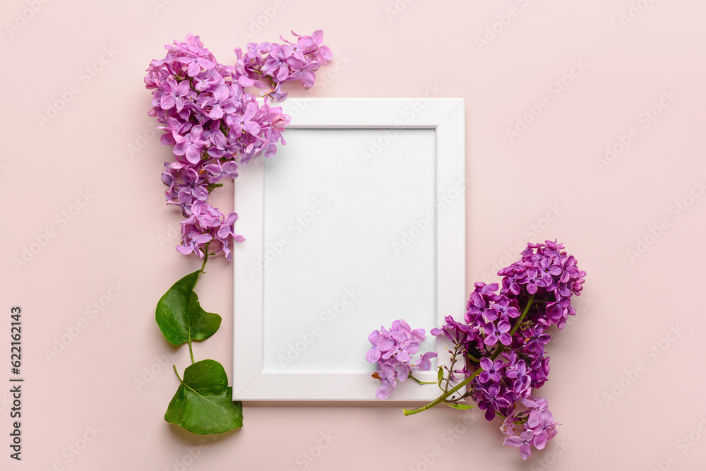 Composition with beautiful lilac flowers and blank frame on beige background