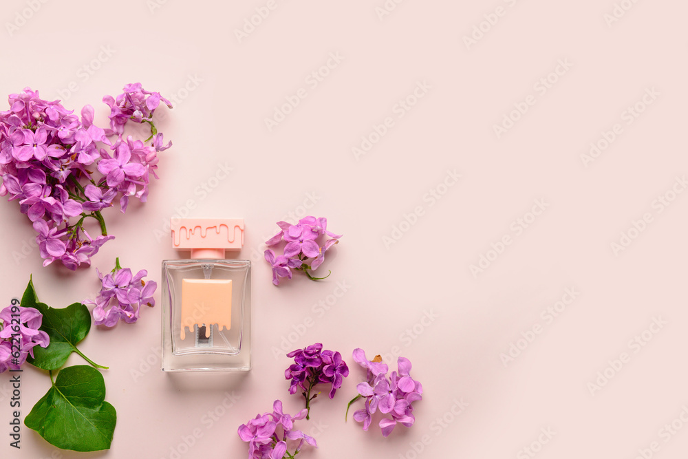 Beautiful lilac flowers and bottle of perfume on beige background