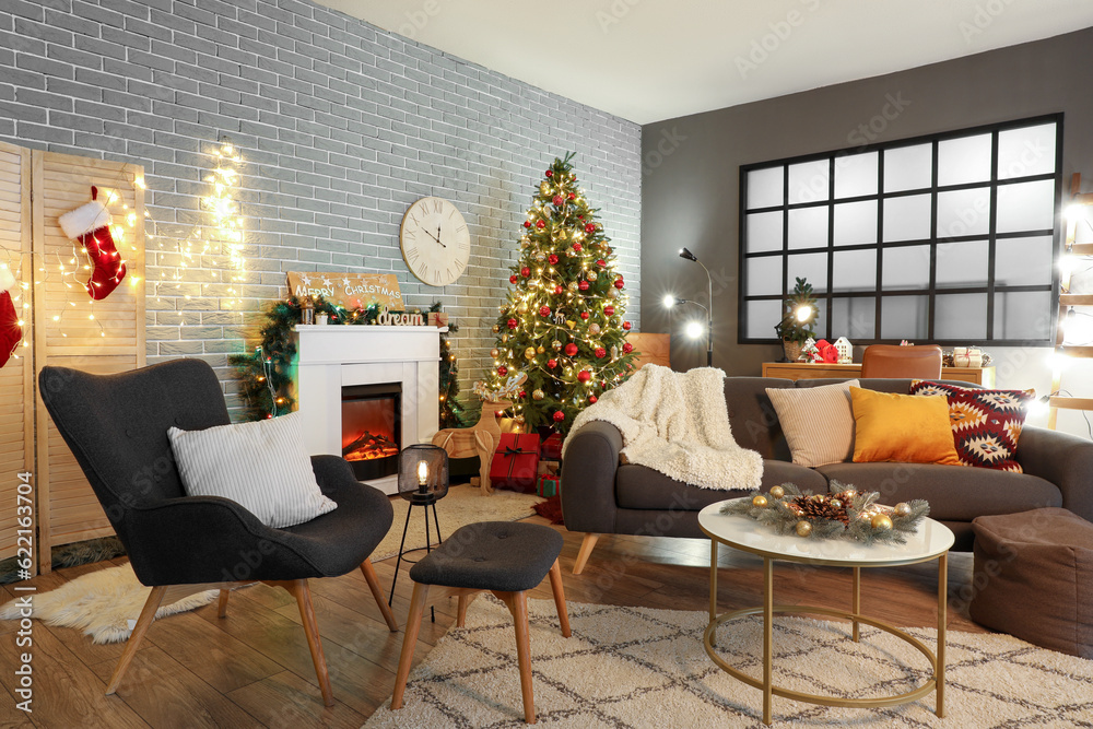 Interior of dark living room with sofa, armchair, fireplace, Christmas tree and glowing lights